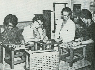 Archive image of Margaret Hood overseeing a seat weaving class.