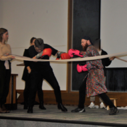 A scene from Alone in the Ring with actors on stage in a mock boxing match