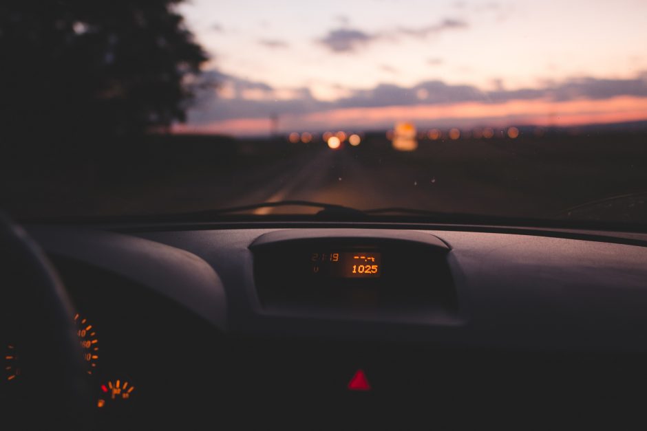 A person driving a car at sunset