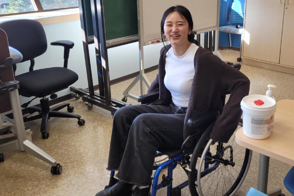 A student tries out a wheelchair to compare the difference between a bad fit and a good fit