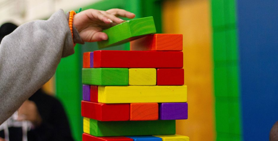 Person piling colourful blocks